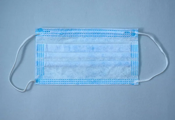 白い紙の質感に隔離された青い医療用マスク — ストック写真