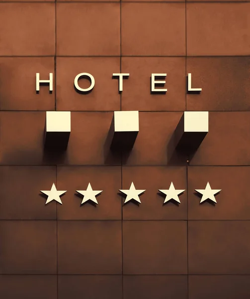 golden Board or signboard for a three stars hotel. 3 stars hotel signage board. Wall of a building with a sign for a hotel with star declaration