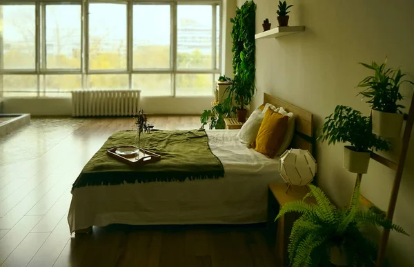 King size bed with white and green bedding, large window and a painting on the wall in a bright hotel room interior. green plants around bed.