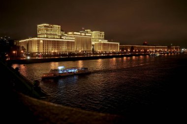 MOSCOW, RUSSIA - 18 Ekim 2020: Rusya Savunma Bakanlığı panoramik görüşü, Novoandreevsky Köprüsü, Moskova. Gece sahnesi. Tekne Moskova nehrinde yol alıyor.