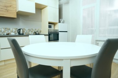 Mutfak odasının beyaz renkli parlak fotoğrafı elektrikli fırın, buzdolabı ve ahşap masa dolapları ve boş masalı diğer ekipmanlar. iç arkaplan