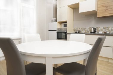 Mutfak odasının beyaz renkli parlak fotoğrafı elektrikli fırın, buzdolabı ve ahşap masa dolapları ve boş masalı diğer ekipmanlar. iç arkaplan