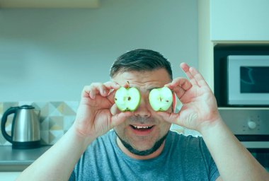 Çekici gülümseyen orta yaşlı adam elinde yeşil taze elmalar tutuyor. Sağlıklı taze gıda konsepti.