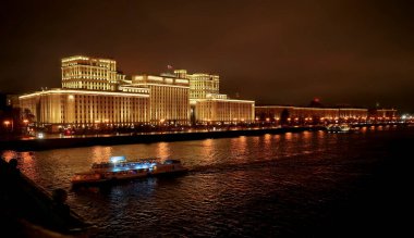 Rusya Savunma Bakanlığı 'nın panoramik manzarası, Novoandreevsky Köprüsü, Moskova. Gece sahnesi. Tekne Moskova nehrinde yol alıyor.