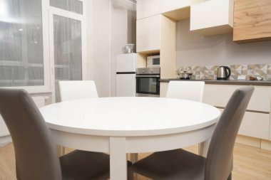 Mutfak odasının beyaz renkli parlak fotoğrafı elektrikli fırın, buzdolabı ve ahşap masa dolapları ve boş masalı diğer ekipmanlar. iç arkaplan