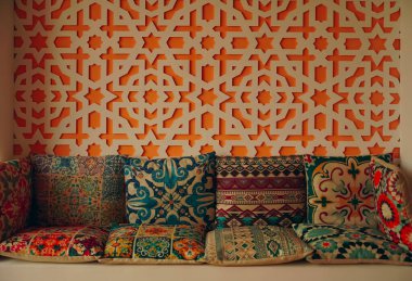  Duvarın yanındaki kanepede renkli Asyalı yastıklar var. Fas iç mimari tarzı.