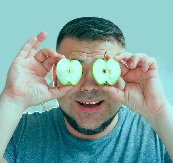 Attractive smiling middle aged man holding green fresh apples. Healthy fresh food concept.