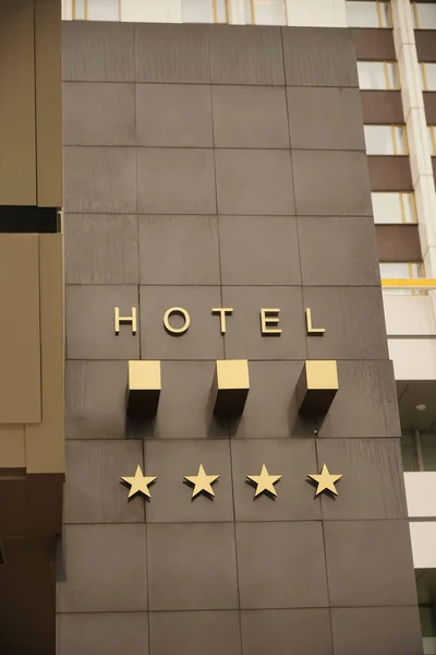 ゴールデンボードや4つ星ホテルの看板 4つ星ホテルの看板 星の宣言があるホテルの看板のある建物の壁 — ストック写真