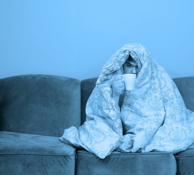 Hasta olduğu için evde. Yakışıklı adamın ateşi ve nezlesi var. Öksür. Orta yaşlı adam soğuk algınlığına ya da gribe yakalandı. Boğazı ağrıyan sağlıksız bir adamın portresi. sabah sahnesi.