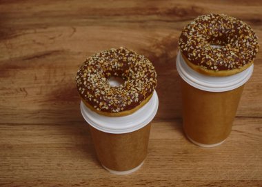 İki çikolatalı çörek ve kahverengi masa arkasında iki fincan kahve. Lezzetli çöller toz fındıkla kaplı, bir sokak fast food 'undan alınmış..