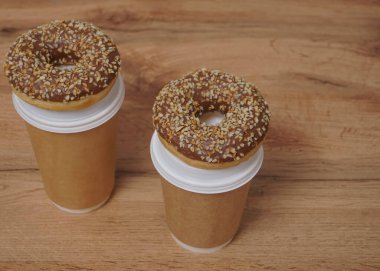 İki çikolatalı çörek ve kahverengi masa arkasında iki fincan kahve. Lezzetli çöller toz fındıkla kaplı, bir sokak fast food 'undan alınmış..