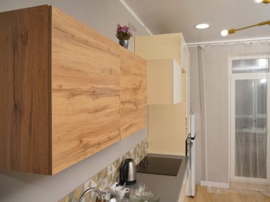 Modern ve şık bir stüdyo daire, işlevsel mutfağı olan beyaz bir daire. Ahşap dolaplar..