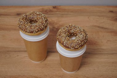 İki çikolatalı çörek ve kahverengi masa arkasında iki fincan kahve. Lezzetli çöller toz fındıkla kaplı, bir sokak fast food 'undan alınmış..