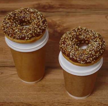 İki çikolatalı çörek ve kahverengi masa arkasında iki fincan kahve. Lezzetli çöller toz fındıkla kaplı, bir sokak fast food 'undan alınmış..