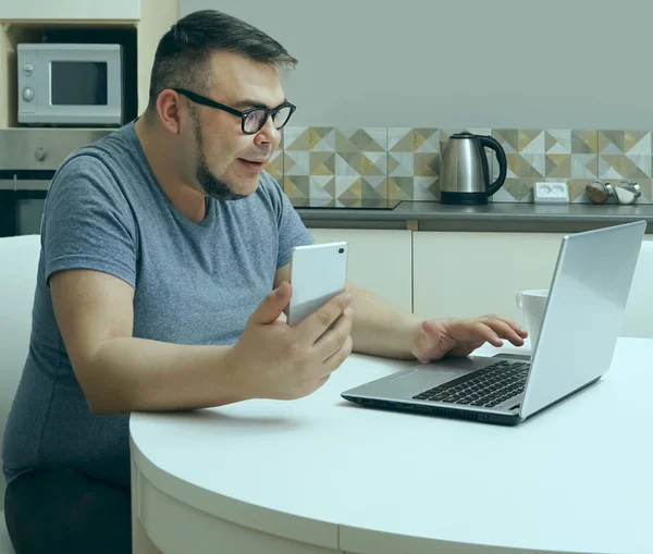 Kaukasische Man Chatten Mobiele Telefoon Keuken Werken Laptop Moderne Keuken — Stockfoto