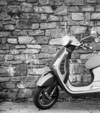 Güzel klasik tasarım gri renkli Vespa scooter, taştan duvar zeminine park etmiş bej koltuklu minder. SALZBURG, AUSTRIA