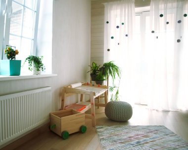 Çocuk odası, mobilya ve doğal yeşil çiçekler. 