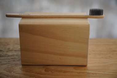 organik bambu diş fırçası, kişisel, taze, ayrıştırılabilir, plastiksiz ürün. Klinik, doğal trendlerin reklamını öneriyor. Ahşap taban, siyah çevresel kıllar. En küçük konsept resmi 