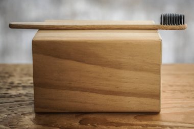 organik bambu diş fırçası, kişisel, taze, ayrıştırılabilir, plastiksiz ürün. Klinik, doğal trendlerin reklamını öneriyor. Ahşap taban, siyah çevresel kıllar. En küçük konsept resmi 
