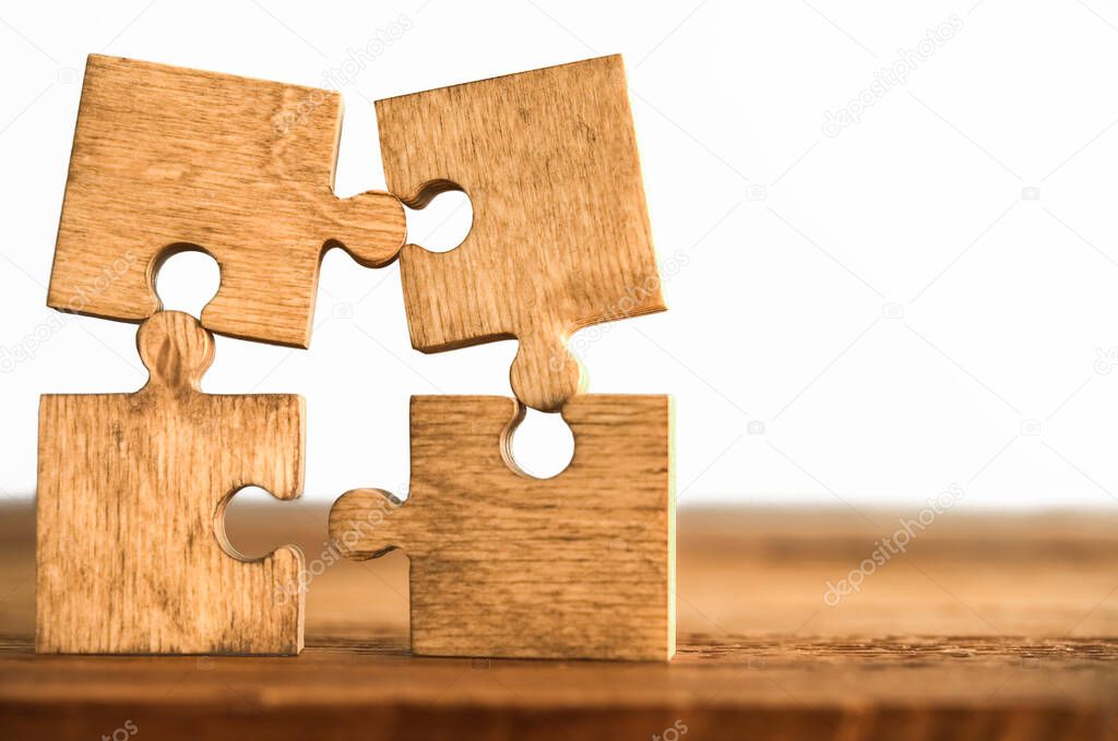 four wooden puzzle pieces. concept of connection people