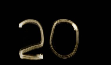 Rakam 20. 20. İki ve Sıfır, sıfır. Karanlık arka planda parlayan numaralar. Soyut gece lambası resmi. Yaratıcı sanatsal altın bokeh. 