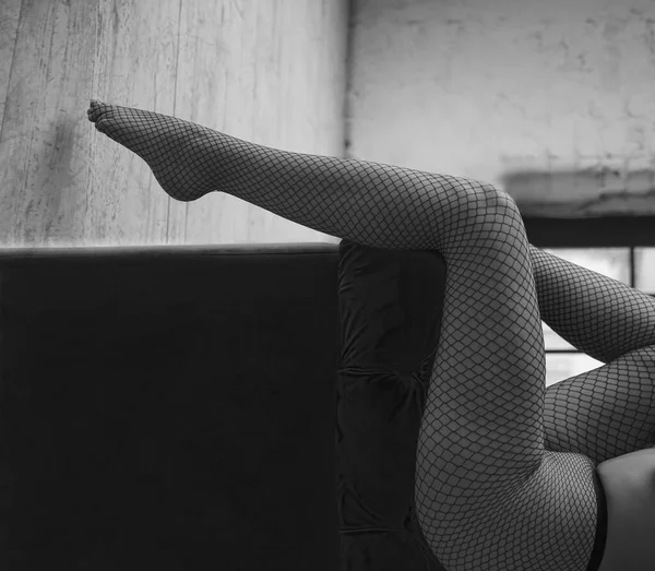Kadın Bacakları Kanepenin Üzerinde Desenli Külotlu Çorap Giyen Bir Kadına — Stok fotoğraf