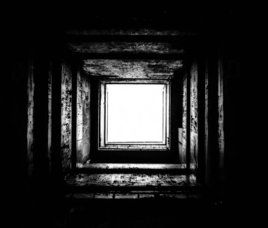 Tünelin sonunda, ucu tünelden parlayan bir ışık olan kare beton drenaj tüneli. Boş kare beton tünel. Kuru, terk edilmiş askeri sığınak. Tünelin sonunda bir ışık.