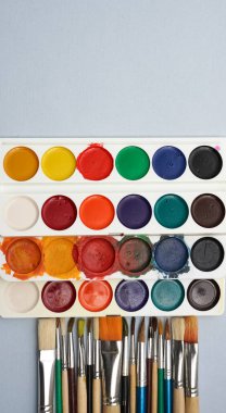 Boş kağıtlar, fırçalar ve suluboya kavanozlarla dolu bir hayat. Suluboya palet arka planı. Yazı için boş kopyalama alanı.