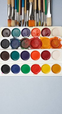 Boş kağıtlar, fırçalar ve suluboya kavanozlarla dolu bir hayat. Suluboya palet arka planı. Yazı için boş kopyalama alanı.