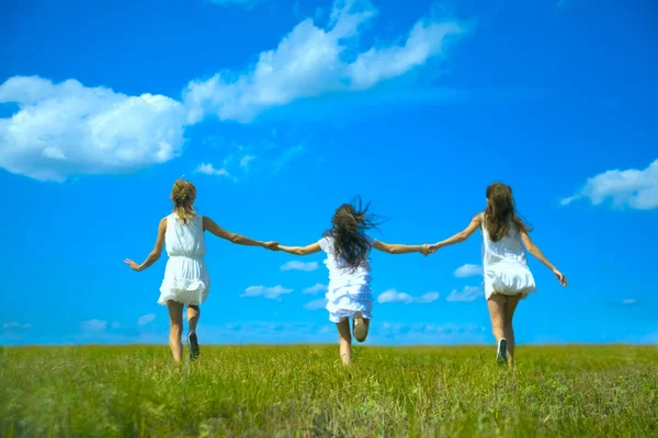 배경의 잔디에서 구름과 소녀들이 뛰어다닌다 여름들 여성들 비문을 빈자리 뒷모습 — 스톡 사진