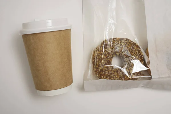 Закрыть Один Шоколадный Пончик Бумажном Пакете Чашку Кофе Белом Столе — стоковое фото