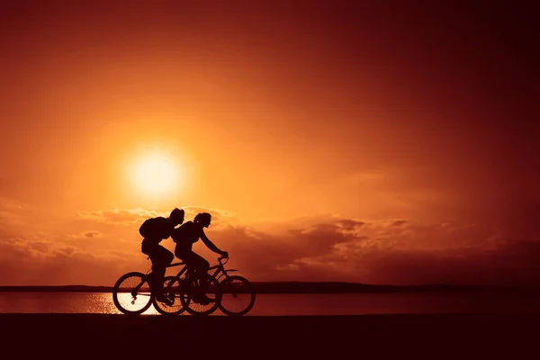 อนสปอร ตบนจ กรยานตอนพระอาท กรยานข ไปตามชายฝ ฬาบนพ นหล งธรรมชาต — ภาพถ่ายสต็อก
