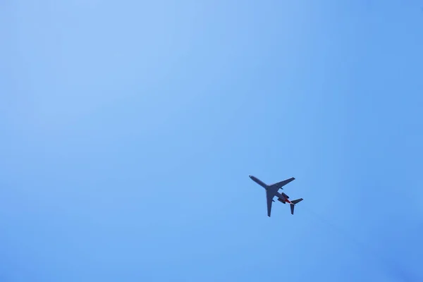 白色的飞机在天空中 底部的观点 起飞和着陆 到达和离开 在蓝色背景下隔离的客机 乘飞机旅行 复制空间 — 图库照片