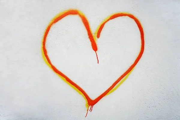 オレンジと黄色のハートが白い壁に描かれています 2月14日 ハッピーバレンタインデー — ストック写真