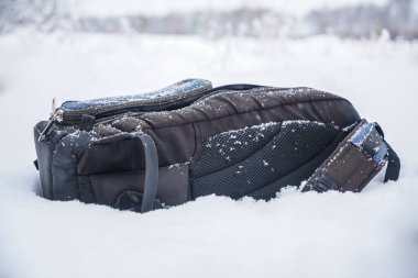 Kar yağışlı kış gününde fotoğrafçılar için sırt çantası. Beyaz kar arka planı. Kış mevsimi. kar yağışıweather condition. 