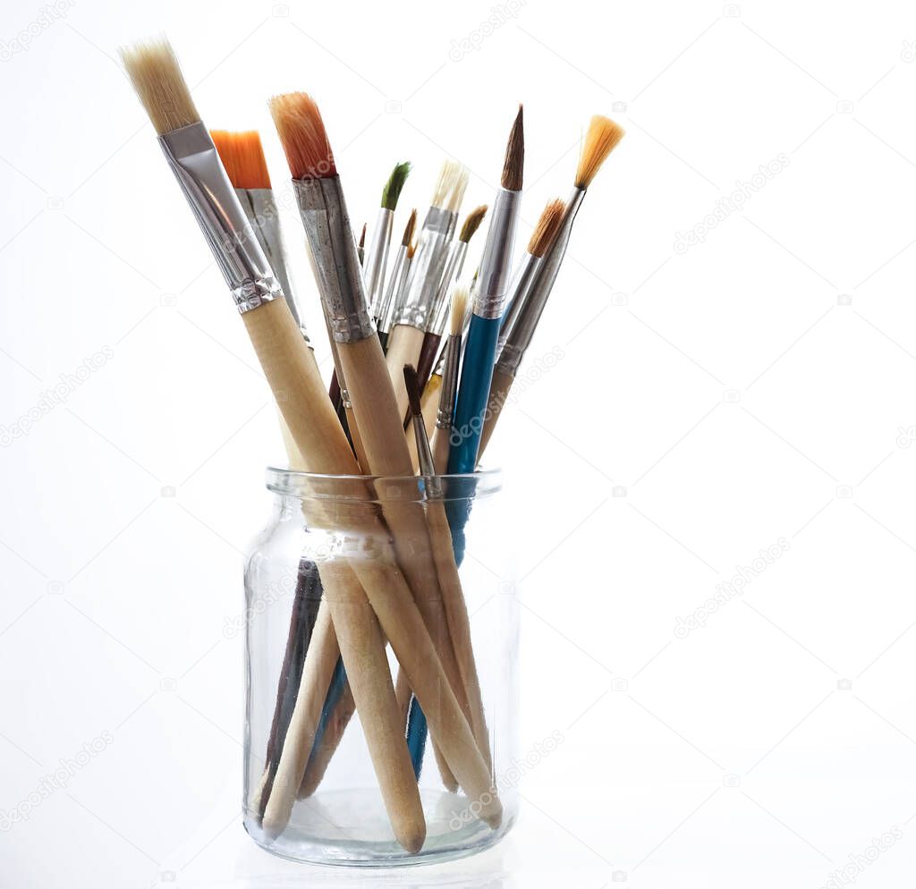 many Paint brushes in a glasses jar isolated on white  background.