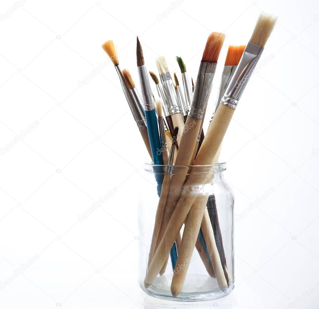 many Paint brushes in a glasses jar isolated on white  background.