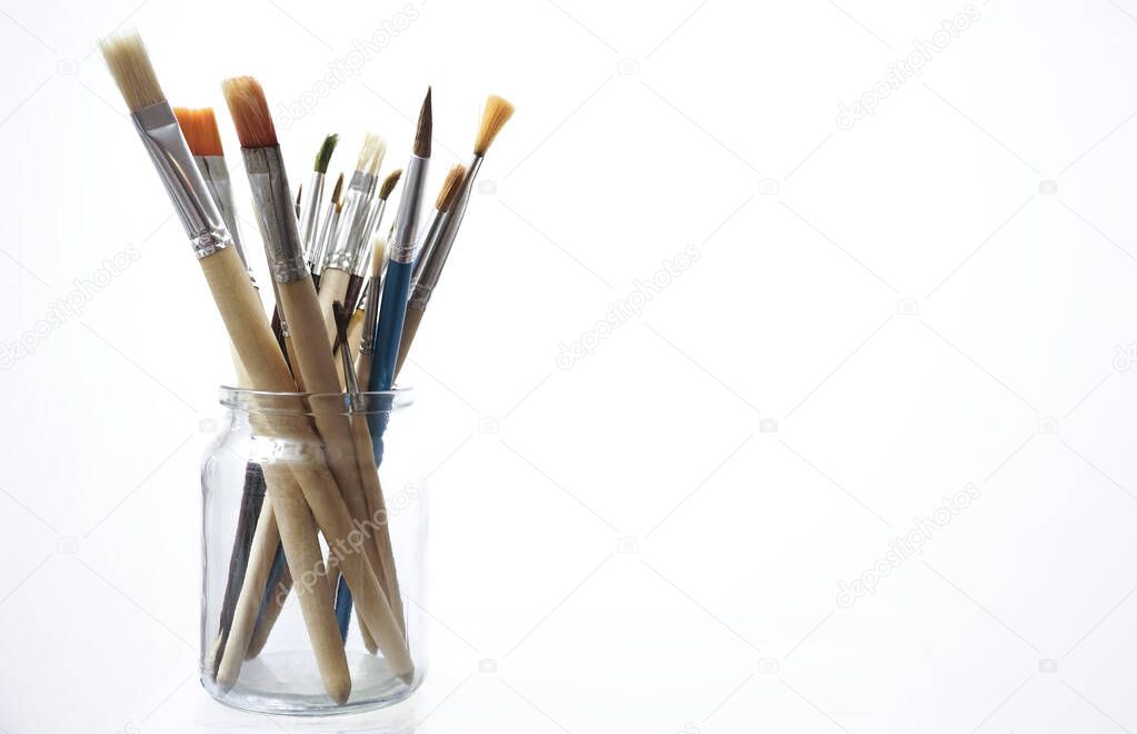 many Paint brushes in a glasses jar isolated on white  background.