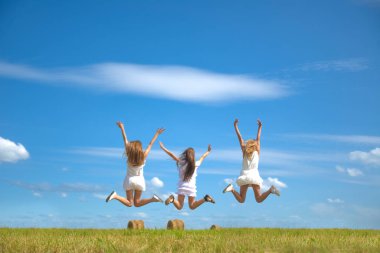 Geriye, üç genç kadının mavi gökyüzü arkaplanının dikiz görüntüsü. Taze yeşil çimenli yaz tarlası. Yüzü tanınmayan biri yok. Eller yukarı! Eller yukarı!.