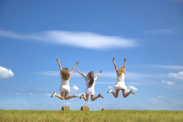 여성이 하늘을 배경으로 점프하는 장면이 보입니다 여름의 들판과 풀들이 있노라 — 스톡 사진
