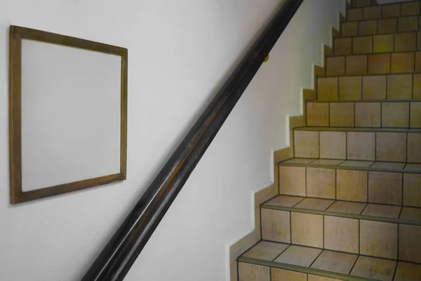 tiled  stair with white wall and wooden empty frame hanging, retro design.  Welcome.  Hotel interior.