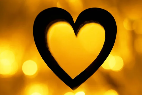Sylwetka Czarnego Serca Żółtym Złotym Tle Oświetlenie Girlandy Bokeh Nocy — Zdjęcie stockowe
