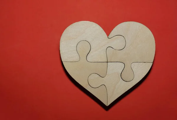 Komplette Hölzerne Herzform Puzzle Auf Rotem Papier Hintergrund Vier Stücke — Stockfoto