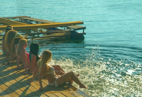 美しい夏の日没の光に水を撒く幸せな若い女性のグループ — ストック写真