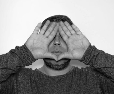 Adam iki eliyle de gözlerini kapatıyor. beyaz veya gri arkaplanda izole edilmiş.