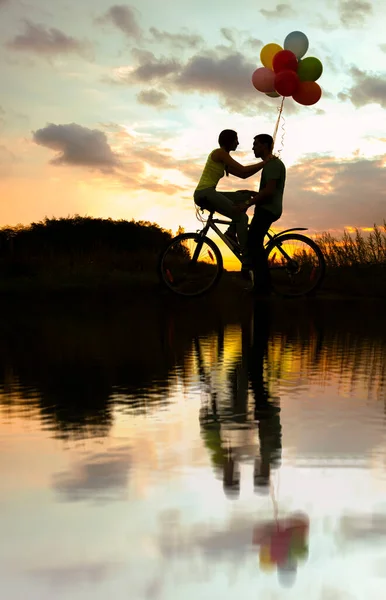 Силуэты Двух Красивых Взрослых Людей Сидящих Велосипеде Девушка Держит Красочные — стоковое фото