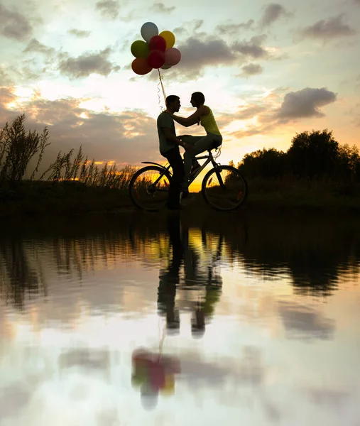 아름다운 성인두 사람이 자전거를 실루엣입니다 석양에 풍선을 — 스톡 사진