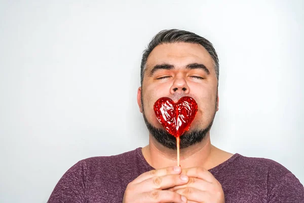 Knappe Man Met Rode Lolly Vorm Van Een Rood Hart — Stockfoto