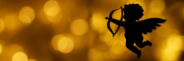 キューピッドの姿のシルエット黄金のボケを背景に弓を持つ天使 テキスト用の場所 幸せなバレンタインデーのアイデア 2月14日 — ストック写真