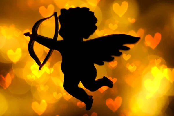 キューピッドの姿のシルエット黄金のボケを背景に弓を持つ天使 テキスト用の場所 幸せなバレンタインデーのアイデア 2月14日 ハートボケー — ストック写真